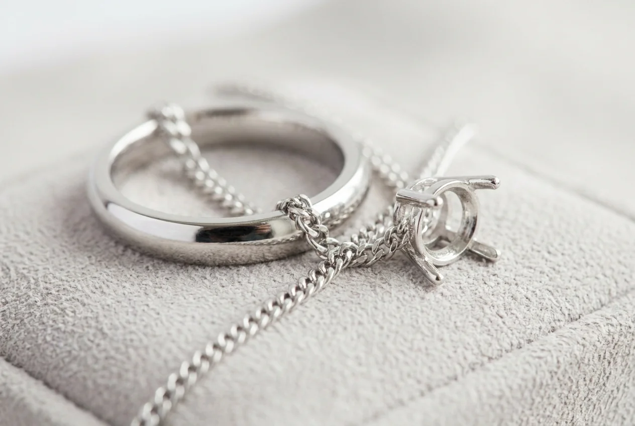White gold band, fine chain and claw setting on grey suede