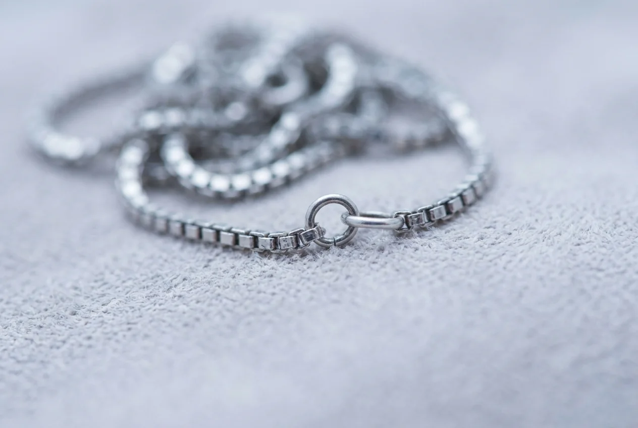 Macro of a fine silver chain with one link opened