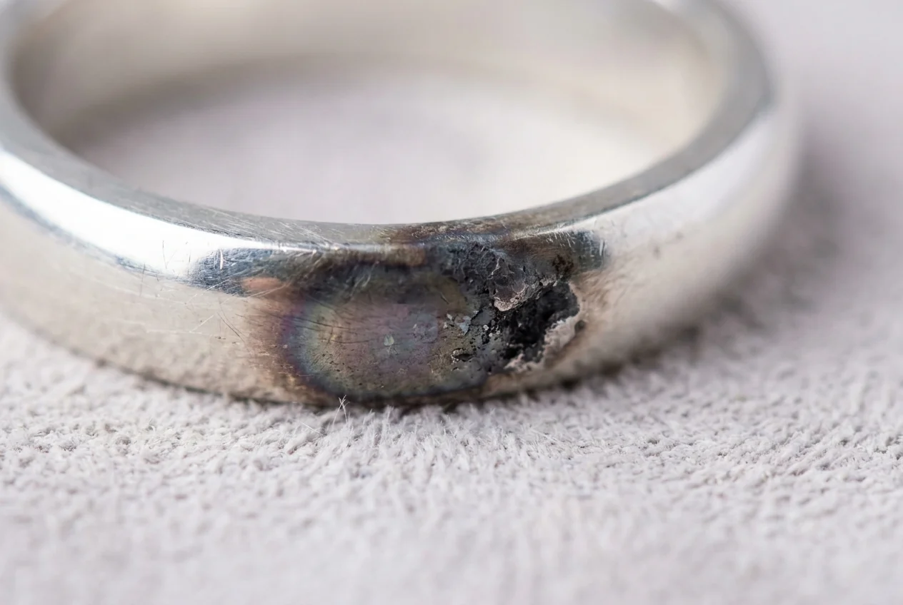 Sterling silver band with a dark firescale patch across the polished surface